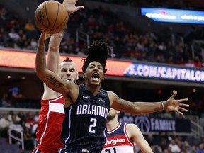 Orlando Magic guard Elfrid Payton (2) reacts after he was fouled while shooting against Washington Wizards center Marcin Gortat (13), from Poland, and forward Tomas Satoransky (31), from the Czech Republic, during the first half of an NBA basketball game Friday, Jan. 12, 2018, in Washington.