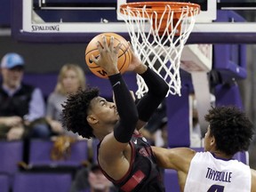 Stanford's Daejon Davis, left, grabs a rebound in front of Washington's Matisse Thybulle in the second half of an NCAA college basketball game Saturday, Jan. 13, 2018, in Seattle.