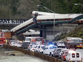 FILE - In this Dec. 18, 2017, file photo, cars from an Amtrak train lay spilled onto Interstate 5 below as some remain on the tracks above in DuPont, Wash. The engineer operating the train says he misjudged where he was along the new high-speed route before it hurtled into a curve at more than twice the speed limit. The National Transportation Safety Board on Thursday, Jan. 25, 2018, offered a summary of its interviews with the 55-year-old engineer and the 48-year-old conductor. Three people were killed and dozens were injured on the inaugural run of the Tacoma to Portland train route.