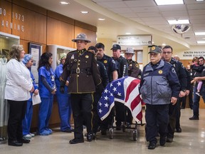 Officers and medical staff take part in a procession for officer Daniel McCartney, of Yelm, at St. Joseph Medical Center in Tacoma, Wash., on Monday, Jan. 8, 2018. The department said McCartney was responding to a home invasion in the Frederickson area, late Sunday night when he was shot during a foot chase.
