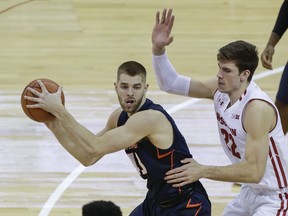 CORRECTS ILLINOIS PLAYER TO MICHAEL FINKE, INSTEAD OF MARK SMITH - Illinois' Michale Finke (43) looks to pass as Wisconsin's Ethan Happ (22) defends during the first half of an NCAA college basketball game Friday, Jan. 19, 2018, in Madison, Wis.