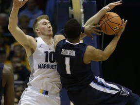 Marquette's Sam Hauser (10) is called for a foul as Villanova's Jalen Brunson tries to shoot during the first half of an NCAA college basketball game Sunday, Jan. 28, 2018, in Milwaukee.