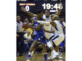 Kentucky guard Shai Gilgeous-Alexander is pressured by West Virginia's Jevon Carter (2) and Sagaba Konte during the first half of an NCAA college basketball game Saturday, Jan. 27, 2018, in Morgantown, W.Va.