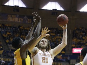 Texas forward Dylan Osetkowski (21) shoots while being defended by West Virginia forward Wesley Harris (21) during the first half of an NCAA college basketball game, Saturday, Jan. 20, 2018, in Morgantown, W.Va.