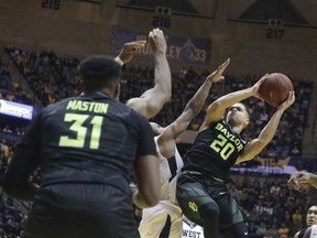 Baylor guard Manu Lecomte (20) drives to the basket while being defended by West Virginia guard Jevon Carter (2) during the first half of an NCAA college basketball game Tuesday, Jan. 9, 2018, in Morgantown, W.Va.