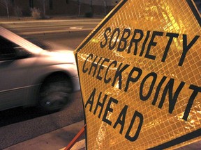 FILE - In this Dec. 29, 2011 file photo, a car approaches a sobriety checkpoint set up along a busy street in Albuquerque, N.M.  A prestigious scientific panel is recommending that states significantly lower their drunken driving thresholds as part of a blueprint to eliminate the "entirely preventable" 10,000 alcohol-impaired driving deaths in the United States each year.