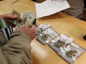 In this Jan. 1, 2018 photo, a customer purchases marijuana at Harborside marijuana dispensary in Oakland, Calif. Attorney General Jeff Sessions is going after legalized marijuana. Sessions is rescinding a policy that had let legalized marijuana flourish without federal intervention across the country.  That's according to two people with direct knowledge of the decision.