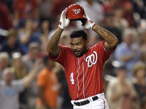 FILE - In this Aug. 13, 2017 file photo, Washington Nationals' Howie Kendrick throws off his batting helmet as he celebrates his walkoff grand slam in the 11th inning of the second baseball game of a doubleheader against the San Francisco Giants in Washington.  The Nationals have agreed to terms on a $7 million, two-year contract with veteran outfielder Howie Kendrick.