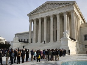 In this Dec. 4, 2017 photo, people stand in line to enter the Supreme Court in Washington. The Supreme Court is agreeing to decide the legality of the latest version of President Donald Trump's ban on travel to the United States by residents of six mostly Muslim countries The justices plan to hear argument in April and issue a final ruling by late June. The action follows last month's ruling by the federal appeals court in San Francisco that struck down the travel ban.