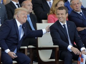 FILE - In this July 14, 2017, file photo, French President Emmanuel Macron, right, and U.S. President Donald Trump attending the traditional Bastille Day military parade on the Champs Elysees, in Paris. Trump is expected to invite Macron to the U.S. on the first state visit of the Trump administration.
