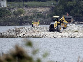 FILE - In this Sept. 13, 2017, file photo, workers are shown at San Jacinto River Waste Pits near the Interstate 10 bridge over the river in Channelview, Texas. The Environmental Protection Agency says an unknown amount of a dangerous chemical linked to birth defects and cancer may have washed downriver from a Houston-area Superfund site during the flooding from Hurricane Harvey. A top manager who supervises the Environmental Protection Agency's program for cleaning up the nation's most contaminated properties and waterways told Congress the government needs to plan for the ongoing threat posed to Superfund sites by climate change.