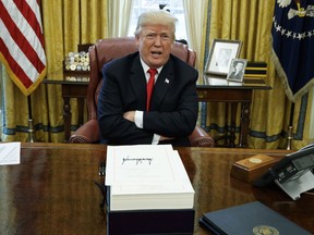 FILE - In this Dec. 22, 2017, file photo, President Donald Trump speaks with reporters after signing the tax bill and continuing resolution to fund the government, in the Oval Office of the White House in Washington. For Trump, that energy-sapping 2017 cocktail of blistering presidential tweets, salacious White House infighting and jaw-dropping feuds with foreign adversaries has given way to, well, more of the same. Indeed, the first three days of 2018 brought a new array of targets for the president and the return of some familiar foes.