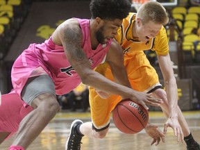 Nevada forward Elijah Foster (12) and Wyoming forward Hayden Dalton (20) scramble for the ball during the first half of an NCAA college basketball game in Laramie, Wyo., Wednesday, Jan. 24, 2018.