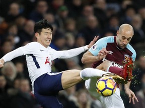 Tottenham's Son Heung-min, left, fights for the ball with West Ham's Pablo Zabaleta during the English Premier League soccer match between Tottenham Hotspur and West Ham United at Wembley Stadium in London, Thursday, Jan. 4, 2018.