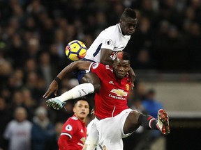 Manchester United's Paul Pogba jumps for the ball with Tottenham's Davinson Sanchez, top, during the English Premier League soccer match between Tottenham Hotspur and Manchester United at Wembley stadium in London, England, Wednesday, Jan. 31, 2018.