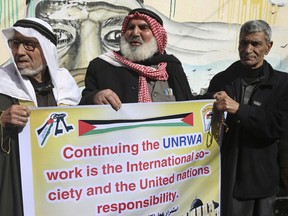 Refugees protest against the U.S. for withholding $65 million from Palestinian aid programs, in front of the UNRWA offices in the Nusseirat refugee camp, central Gaza Strip, Wednesday, Jan. 17, 2018. The Trump administration on Tuesday cut tens of millions of dollars in money for Palestinian refugees, demanding that the U.N. agency responsible for the programs undertake a "fundamental re-examination," the State Department said.