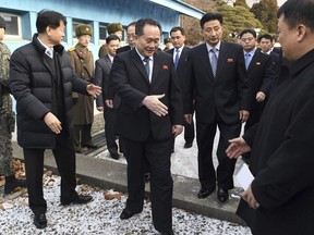 Head of North Korean delegation Ri Son Gwon, center, is greeted by South Korean officials after he crosses the border line to attend their meeting at Panmunjom in the Demilitarized Zone in Paju, South Korea, Tuesday, Jan. 9, 2018. North Korea agreed Tuesday to send a delegation to next month's Winter Olympics in South Korea, Seoul officials said, as the bitter rivals sat for rare talks at the border to discuss how to cooperate in the Olympics and improve their long-strained ties. (Korea Pool via AP)