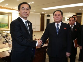 South Korean Unification Minister Cho Myoung-gyon, left, shakes hands with the head of North Korean delegation Ri Son Gwon after their meeting at the Panmunjom in the Demilitarized Zone in Paju, South Korea, Tuesday, Jan. 9, 2018. The rival Koreas took steps toward reducing their bitter animosity during rare talks Tuesday, as North Korea agreed to send a delegation to next month's Winter Olympics in South Korea and reopen a military hotline. (Korea Pool via AP)