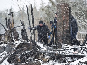 RCMP officers and a representative of the Medical Examiner's office search the scene of a house destroyed in a weekend fire in Pubnico Head, N.S. on Monday, Jan. 8, 2018. The fire left four people dead, including at least two children, according to a relative.