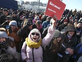 Demonstrators shout slogans holding a poster which reads "Elections without me! Strike." during a rally in Vladivostok, Russia, Sunday, Jan. 28, 2018. Opposition politician Alexey Navalny calls for nationwide protests following Russia's Central Election Commission's decision to ban his presidential candidacy.