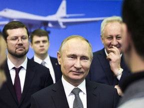 Russian President Vladimir Putin, center, speaks to employees as he visits an aircraft making plant in Kazan, Russia, Thursday, Jan. 25, 2018. Putin watched a demonstration flight of a Tu-160 strategic bomber and met with workers.