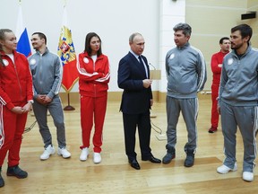 Russian President Vladimir Putin, center, poses for a photo with Russian athletes who will take part in the upcoming 2018 Pyeongchang Winter Olympic Games in South Korea, at the Novo-Ogaryovo residence outside in Moscow, Russia, Wednesday, Jan. 31, 2018. As punishment for what it deemed a doping scheme during the 2014 Sochi Olympics, the International Olympic Committee has invited 169 Russians to compete under a neutral flag using the name "Olympic Athletes from Russia."