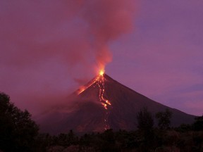 Molten lava flows down the slopes of Mayon volcano during its mild eruption as seen from Legazpi city, Albay province, southeast of Manila, Philippines Tuesday, Jan. 30, 2018. Mayon's lava fountaining has flowed up to 3 kilometers (1.86 miles) from the crater in a dazzling but increasingly dangerous eruption.