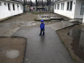 A migrant boy walks in the "Krnjaca" refugee centre near Belgrade, Serbia, Wednesday, Jan. 17, 2018. Several thousand migrants have been stuck in Serbia waiting for a chance to move on.