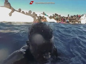 This frame of a video taken by the Italian Coast Guard on Jan. 6, 2018, in the Mediterranean Sea off Libya, shows migrants being rescued from dinghies as they try to cross to Italy. As many as 64 African migrants, including a mother whose surviving 3-year-old child desperately clung to her, are feared dead after a traffickers' overcrowded rubber dinghy from Libya started taking on water and deflating in the Mediterranean Sea.