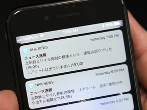 A smartphone shows Tuesday's NHK television's news website saying "North Korea appears to have fired a missile," "The government: Seek shelter inside buildings and basements," second from top, in Tokyo Wednesday, Jan. 17, 2018. The Japan's public broadcaster mistakenly sent an alert on Tuesday warning citizens of a North Korean missile launch and urging them to seek immediate shelter, then minutes later corrected it, top, days after a similar error in Hawaii. The message at top reads: "The flash of North Korea's missile launch was a mistake."
