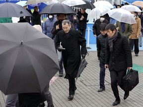 Participants take refuge during an evacuation drill simulating a North Korea ballistic missile attack in Tokyo, Monday, Jan. 22, 2018.