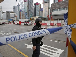 A police officer from explosive ordinance disposal is deployed to the scene in the Wan Chai district of Hong Kong, Wednesday, Jan. 31, 2018. Hong Kong police sealed off part of a busy downtown neighborhood on Wednesday after an unexploded bomb was found during construction work in the Asian financial center.