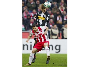 Cologne's  Milos Jojic, front, and Moenchengladbach's  Nico Elvedi  challenge for the ball during the German first division Bundesliga soccer match between 1. FC Cologne and Borussia Moenchengladbach, in Cologne, Germany, Sunday, Jan. 14, 2018.