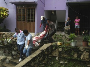 In this Aug. 29, 2017 file photo, a body wrapped in a bloodstained sheet is removed from an apartment building where a woman and two men were executed, in the Alta Progreso neighbourhood of Acapulco, Mexico.