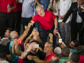 FILE - In this Jan. 24, 2018 file photo, former President Luiz Inacio Lula da Silva greets supporters during a visit to the metallurgic syndicate headquarters in Sao Bernardo do Campo, Brazil. A new poll published Wednesday, Jan. 31, 2018, shows da Silva enjoying a strong lead ahead of the Oct. 7 presidential elections despite his recent conviction on corruption charges. The Datafolha poll is the first since an appeals court last week upheld a corruption conviction against da Silva, a decision likely to knock him out of contention.