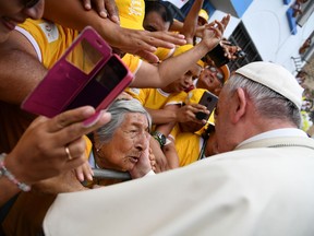 Pope Francis greets a woman after blessing her as he toured around the Plaza de Armas, in Trujillo, Peru, Saturday, Jan. 20, 2018. Francis consoled Peruvians who lost their homes and livelihoods in devastating floods last year, telling them Saturday they can overcome all of life's "storms" by coming together as a community and stamping out the violence that plagues this part of the country.