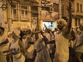 In this Jan. 22, 2018 photo, members of the Paraiso do Tuiuti samba school rehearse their dances and songs that make reference to Brazil's history with slavery, in the streets of Rio de Janeiro, Brazil. "It's not just racism against blacks or whites," said Dandara Silva, a hairdresser and dancer in the group. "There is a form of social slavery and we are fighting against that."