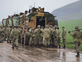 Turkish Army soldiers form a convoy of armoured personnel carriers near the border with Syria, in the outskirts of Hassa, Turkey, Tuesday, Jan. 23, 2018. Turkey's Foreign Minister Mevlut Cavusoglu has announced that a second Turkish soldier has been killed in action in Turkey's military offensive on a Kurdish-held enclave in northern Syria.