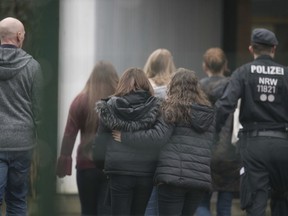 Police accompanies students at a school in Luenen, Germany, Tuesday, Jan. 23, 2018. Police say a student has been killed by a fellow pupil at a school in western Germany. Dortmund police said the incident happened Tuesday morning at a school in the nearby town of Luenen. Police said a minor has been arrested and investigations into the killing are ongoing. Students and teachers at the school are getting psychological counseling.