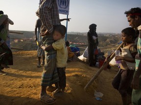A Rohingya refugee boy who was staying in no-man's land at Bandarban between Myanmar and Bangladesh border, clings to his father after arriving at Balukhali refugee camp 50 kilometres (32 miles) from, Cox's Bazar, Bangladesh Wednesday, Jan. 24, 2018. Rohingya Muslims who fled persecution in Myanmar say some of them had returned home several times over past decades, and they're in no mood to repatriate again. Although, Myanmar says it's ready for a gradual repatriation of Muslim Rohingya refugees chased out by the Buddhist-majority country's military. More than 680,000 Rohingya Muslims are now living in sprawling and squalid refugee camps in Bangladesh.