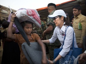 Malaysian actress Michelle Yeoh, right, distributes blanket to a Rohingya refugee at Balukhali refugee camp near Cox's Bazar, Bangladesh, Saturday, Jan. 27, 2018. A special delegation led by Michelle Yeoh and Malaysian Armed Forces Chief Gen. Raja Mohamad Affandi Saturday visited Rohingya refugee camp and distributed relief material items apart from evaluating the impact of the aid.