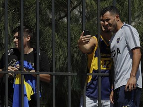 Carlos Tevez poses for a photo with a fan after attending a Boca Juniors training session in Cardales, Argentina, Tuesday, Jan. 9, 2018. Tevez will be officially presented today as part of Boca Juniors team, for third time in his career.