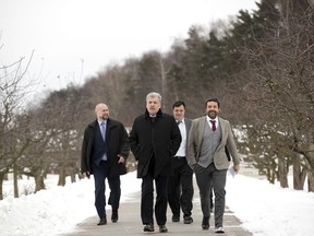 In this photo taken on Friday, Jan. 26, 2018, the Communist Party's candidate for the 2018 Russian presidential election Pavel Grudinin, center, walks, in the Lenin state farm outside Moscow, Russia. Russia's Communist Party has nominated a millionaire farm director who does not believe in the tenets of Communism as its presidential candidate.