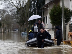 Rescue workers evacuate residents in a flooded street of Villeneuve-Saint-Georges, outside Paris, where the Yerres river floods Thursday, Jan.25, 2018. Rivers across France kept swelling as more rain hit the country Thursday, with 15 departments across the country remaining on alert for floods. In addition to Paris, where the Seine river is expected to keep rising until Saturday, the other regions threatened are in the north and east of the country.