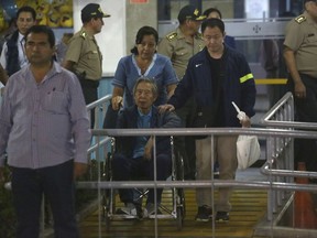 Former President Alberto Fujimori is wheeled out the hospital he was interned, in Lima, Peru, Thursday, Feb. 4 2018. Peru's President Pedro Pablo Kuczynski granted a medical pardon to former strongman Fujimori who was serving a 25-year sentence for human rights abuses, corruption and the sanctioning of death squads.