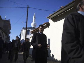 In this Friday, Dec. 8, 2017 file photo, pilgrims walk outside Kirmahalle Cammi mosque in the northeastern Greek town of Komotini. Lawmakers in Greece are set to limit powers of Islamic courts which operate in a border region of the town of Komotini that is home to a 100,000-strong Muslim minority, following a European court challenge.
