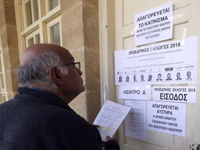 A man checks his ID number for vote in presidential election at a polling station in Nicosia, Cyprus Sunday, Jan. 28, 2018. Cypriots are voting for a new president they hope will overcome years of failure to resolve the island-nation's ethnic division and deliver more benefits from an economy on the rebound after a severe financial crisis.