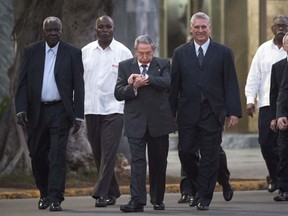 Cuba's President Raul Castro, center, looks at his watch while he walks with Cuba's Vice President Miguel Diaz-Canel and the President of the National Assembly of People's Power, Esteban Lazo Hernandez, left, upon his arrival for a ceremony to unveil a replica of a statue of Cuba's independence hero Jose Marti in Havana, Cuba, Sunday, Jan. 28, 2018. The monument was unveiled on the 165th anniversary of the birth of the Cuban independence hero in a ceremony.