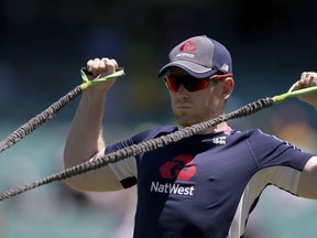 England's Eoin Morgan stretches as his team warms up for their one day international cricket match against Australia in Sydney, Sunday, Jan. 21, 2018.