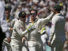Australia's Steve Smith, second right, celebrates with teammates after catching out England's Dawid Malan during the second day of their Ashes cricket test match in Sydney, Friday, Jan. 5, 2018.